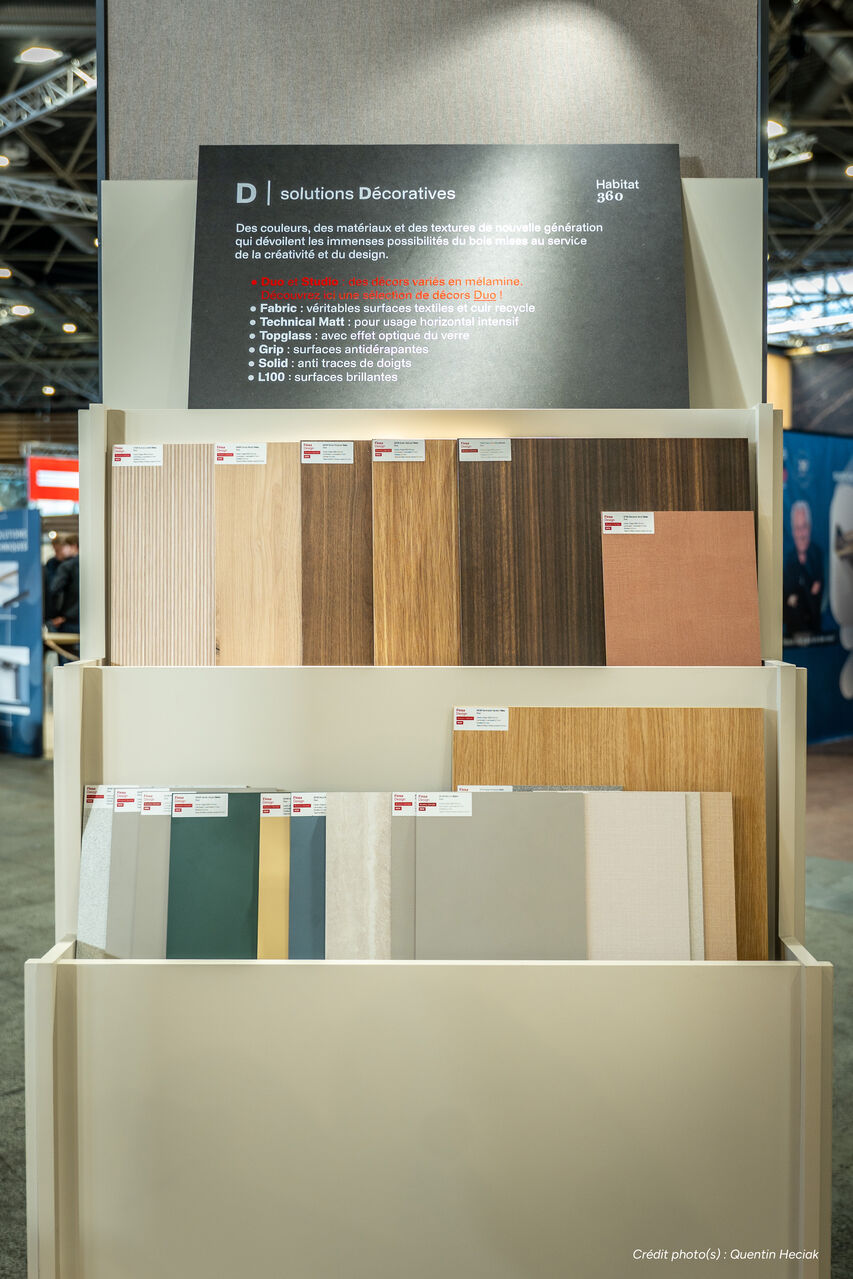 Présentation de matériaux bois et panneaux décoratifs sur un stand éco-conçu pour salon professionnel