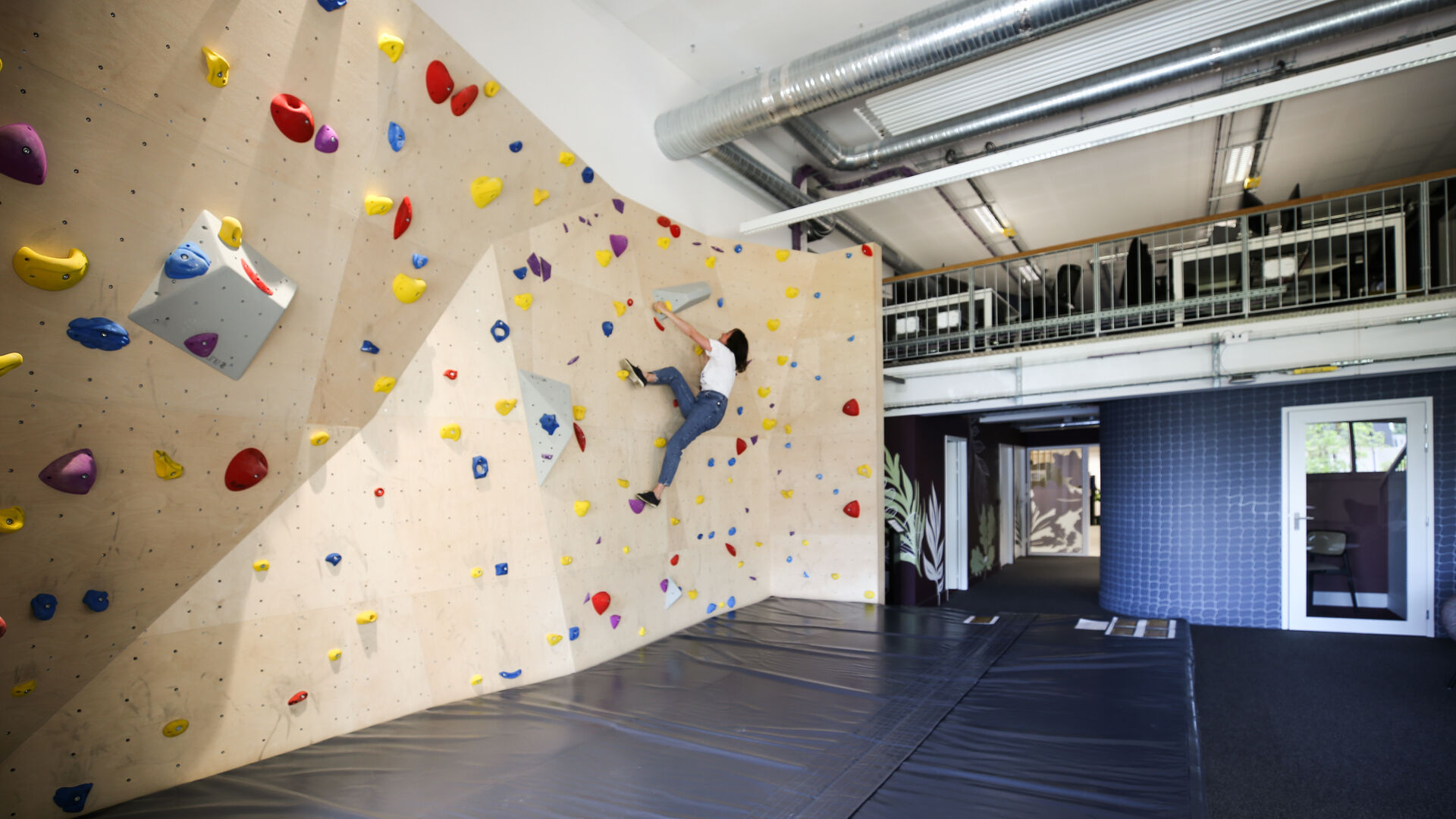 Mur d’escalade intégré aux bureaux Onepoint à Bordeaux, aménagement favorisant la qualité de vie au travail